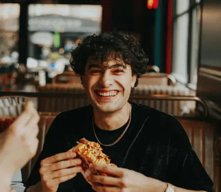 man eating snadwich in bar